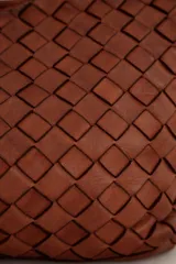 Cartera de cuero marrón con diseño trenzado y asas de hombro trenzadas.