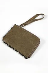 Billetera tipo clutch o monedero de color rojo, con textura de cuero sintético y cierre perimetral de cremallera. Presenta una correa de mano desmontable y está decorada con tachas metálicas plateadas alrededor del borde.