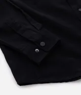 Camisa manga larga de sarga en color verde militar, con cuello inglés, cierre frontal de botones negros y dos bolsillos con solapa en el pecho.