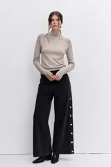 Jersey de punto fino en color negro, con cuello alto y mangas largas ajustadas.