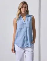 Camisa sin mangas color beige, marca Zac & Rachel, confeccionada en lino. Presenta escote en V, abertura frontal con botones, dos bolsillos delanteros y terminación con botones en los laterales.