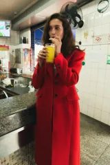 Abrigo largo de Zara confeccionado en mezcla de lana color rojo, con cuello de solapa, manga larga, bolsillos con solapa en el frente y cierre frontal de botones negros.