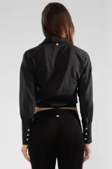 Camisa negra de manga larga con lazo en la cintura y botones nacarados.
