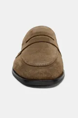 Mocasín plano de mujer confeccionado en serraje, con diseño de antifaz en el empeine, costuras visibles y punta redonda.