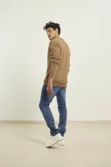 Sweater de punto fino azul con cuello redondo y terminaciones elásticas en canalé.