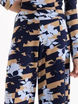 Pantalon de corte recto y tiro medio con diseño de estampado floral sobre un fondo de rayas horizontales en tonos azul marino y beige.