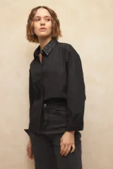 Camisa blanca de algodón con cuello clásico y mangas largas. Detalle de tachas plateadas en el cuello.