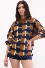 Sweater de punto con estampado geométrico de cuadros en tonos azul, tostado, verde militar y blanco, de corte holgado y mangas largas.
