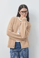 Cardigan de textura suave y efecto fluffy, color beige, con cuello redondo, cierre frontal con botones y puños acanalados.