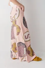Pantalon de corte wide leg y tiro alto, color rosado con estampado de motivos deportivos como pelotas de fútbol y raquetas de tenis. Cuenta con cierre frontal con botón y bolsillos laterales.