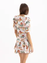 Remera blanca de punto con estampado full print colorido y textura suave, escote redondo profundo, mangas cortas con frunces y hombreras en la copa con puños ajustados, y corte al cuerpo.