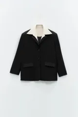 Blazer negro con tres botones en la delantera, dos bolsillos con solapa y cuello agregado estilo camisero color crema.