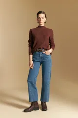 Polera de cuello alto en color blanco, confeccionada en tejido acanalado con un diseño geométrico de relieve que crea un efecto visual estilizado. Presenta un corte al cuerpo y mangas largas, ideal para usar como prenda base o principal.