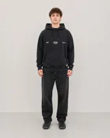 Canguro con capucha y cordones ajustables, color negro con efecto lavado. Presenta un bolsillo frontal tipo canguro y estampado gráfico pequeño en el pecho con el logo de la marca.
