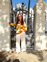 Sweater de punto con diseño geométrico en tonos mostaza, marrón y beige.