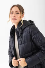 Campera puffer negra con capucha, cierre frontal y diseño acolchado.