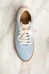 Zapatilla de gamuza celeste con cordones blancos, suela marrón y detalle de la marca "Lemon" en el lateral.