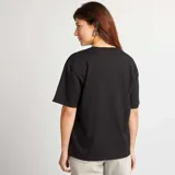 Camiseta de manga corta, cuello redondo y calce oversize en color negro liso.