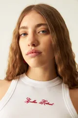 Musculosa blanca acanalada con cuello redondo y bordado rojo en el frente.