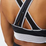 Top deportivo negro de New Balance, modelo Q Speed Shape Shield, con tecnología NB DRYx, tirantes cruzados en la espalda, detalles perforados cortados con láser y paneles de malla para mayor transpirabilidad.