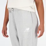 Pantalón de jogging gris con corte ancho, cintura con cordón ajustable y logo de New Balance estampado en blanco en la pierna izquierda.