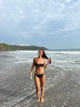 Bombacha de bikini negra tipo vedetina, con laterales fruncidos y finos.