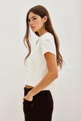 Remera de algodón blanca, de corte crop y diseño holgado con mangas cortas con dobladillo.