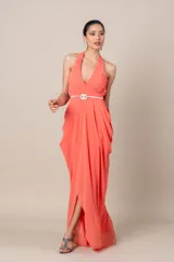 Vestido largo de fiesta color salmón, con cuello halter, corte imperio, falda con movimiento y cinturón blanco fino con hebilla circular.