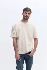 Remera de manga corta color beige, con cuello redondo y estampado pequeño en el pecho con el nombre de la marca Brooksfield.