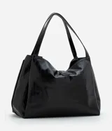 Bolsa tipo shopper de tamaño grande, confeccionada en poliuretano texturizado con acabado brillante. Presenta un diseño estructurado con correas fijas para el hombro, cierre superior mediante botón a presión y un detalle metálico decorativo en la parte frontal.