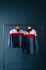 Buzo de felpa con medio cierre, diseño a bloques de color azul, blanco y rojo.