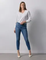 Jean elastizado de tiro alto, marca One Five One. Modelo skinny al tobillo, con pretina con pasadores, cierre y botón metálico. Tres bolsillos delanteros y dos traseros.