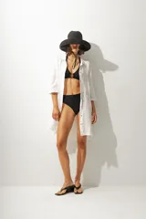 Vestido corto de cuero negro, sin mangas y con cuello redondo. Presenta un corte ajustado al cuerpo.