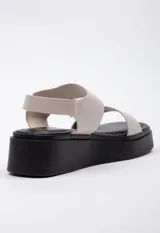Sandalias color beige con plataforma negra de 4,5 cm, tira ancha sobre el empeine y tira con velcro ajustable alrededor del tobillo.