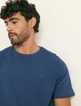 Remera básica de algodón color beige, de manga corta, con cuello redondo y un pequeño detalle bordado en el pecho.
