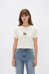 Remera cropped de algodón con cuello redondo, diseño holgado y estampado frontal de una copa con cerezas.