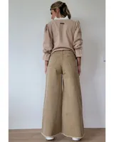 Pantalón de jean color beige, de corte recto y tiro alto, con ruedo deshilachado y cierre frontal con botón y cremallera.