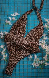 Traje de baño enterizo negro con escote halter y abertura en la espalda.