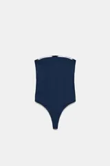 Body strapless de corte ajustado, confeccionado en tejido de poliamida, con cierre inferior mediante botones a presión.