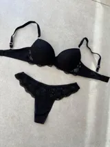 Conjunto de lencería compuesto por un corpiño taza soft con detalles de puntilla y una bombacha tipo less con detalle de encaje en la parte superior.