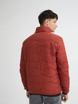 Campera capitoneada color ladrillo, con cuello alto, cierre frontal y bolsillos laterales con cierre.