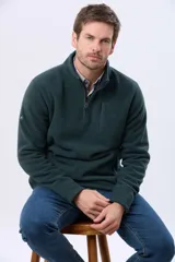 Buzo polar de abrigo en color verde oscuro, con cuello alto y medio cierre frontal. Presenta un bolsillo vertical en el pecho y bolsillos laterales, ideal para climas fríos.