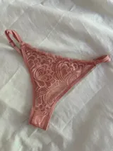 Bombacha tipo tanga de encaje con diseño floral, con laterales de tiras finas ajustables y terminaciones en cinta elástica.