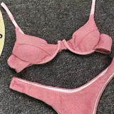 Conjunto de bikini plateado brillante, con corpiño con aros y bombacha tipo tanga.