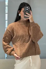 Buzo de chenille color marrón, con cuello alto, mangas largas con puños ajustados y ruedo acanalado.