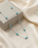 Collar de cadena fina de plata con cinco piedras ovaladas de color turquesa engarzadas a lo largo de la pieza.