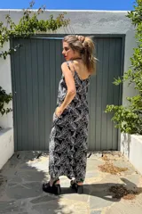 Mono largo confeccionado en fibrana con estampado de hojas blancas sobre fondo negro. Presenta breteles finos, escote en V y un calce holgado y fluido ideal para el verano.