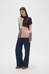 Sweater de punto con diseño de bloques de color en tonos marrón, beige y rosado, de corte holgado, cuello alto y mangas largas.