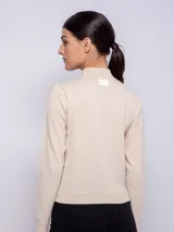 Polera negra de tejido de punto, manga larga y cuello alto.