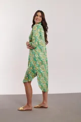 Vestido camisero midi con estampado floral en tonos naranja, rosa y fucsia. Tiene cuello camisero, mangas 3/4 y aberturas laterales.